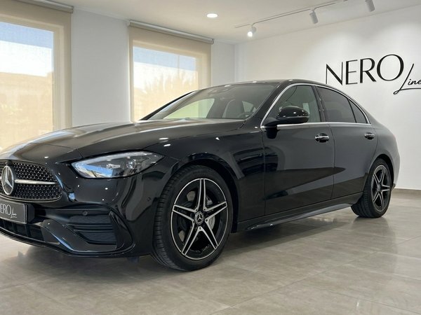Mercedes-Benz C 180 — Front view in Alicante The sleek black Mercedes-Benz C 180 sedan is presented from a front three-quarter view inside a showroom in Alicante.