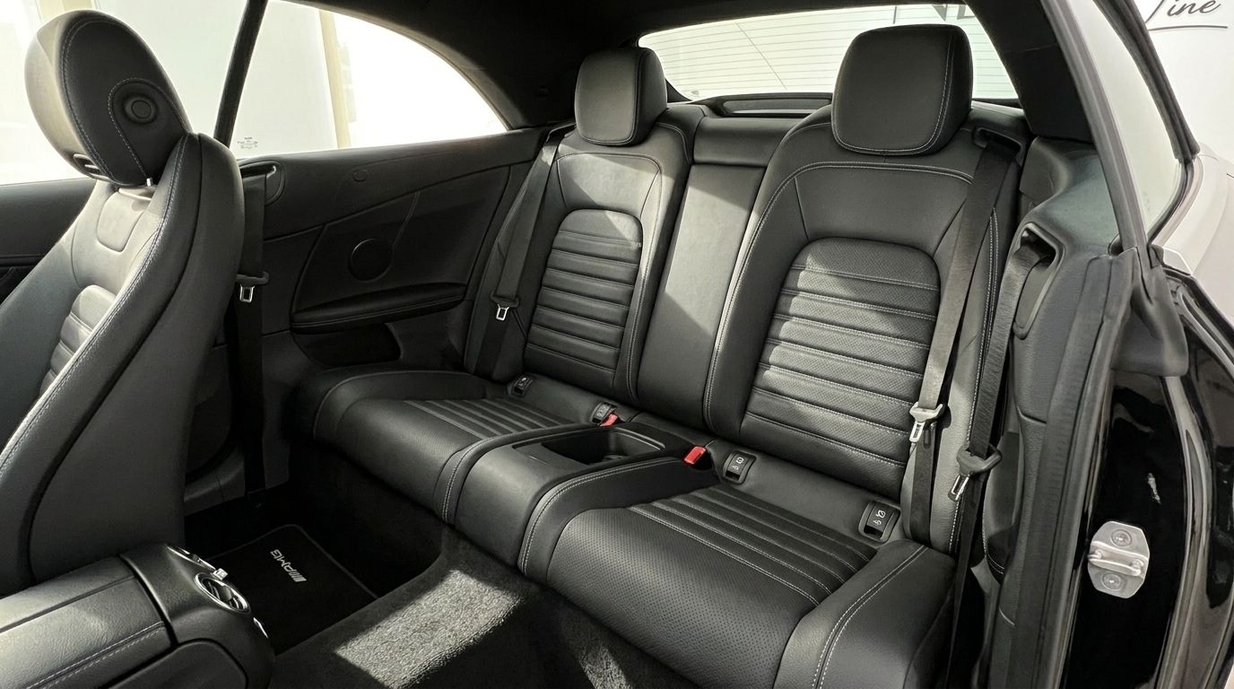 The luxurious black leather rear seats with white stitching of the Mercedes-Benz C-Class Cabriolet in Alicante, ready for comfort.