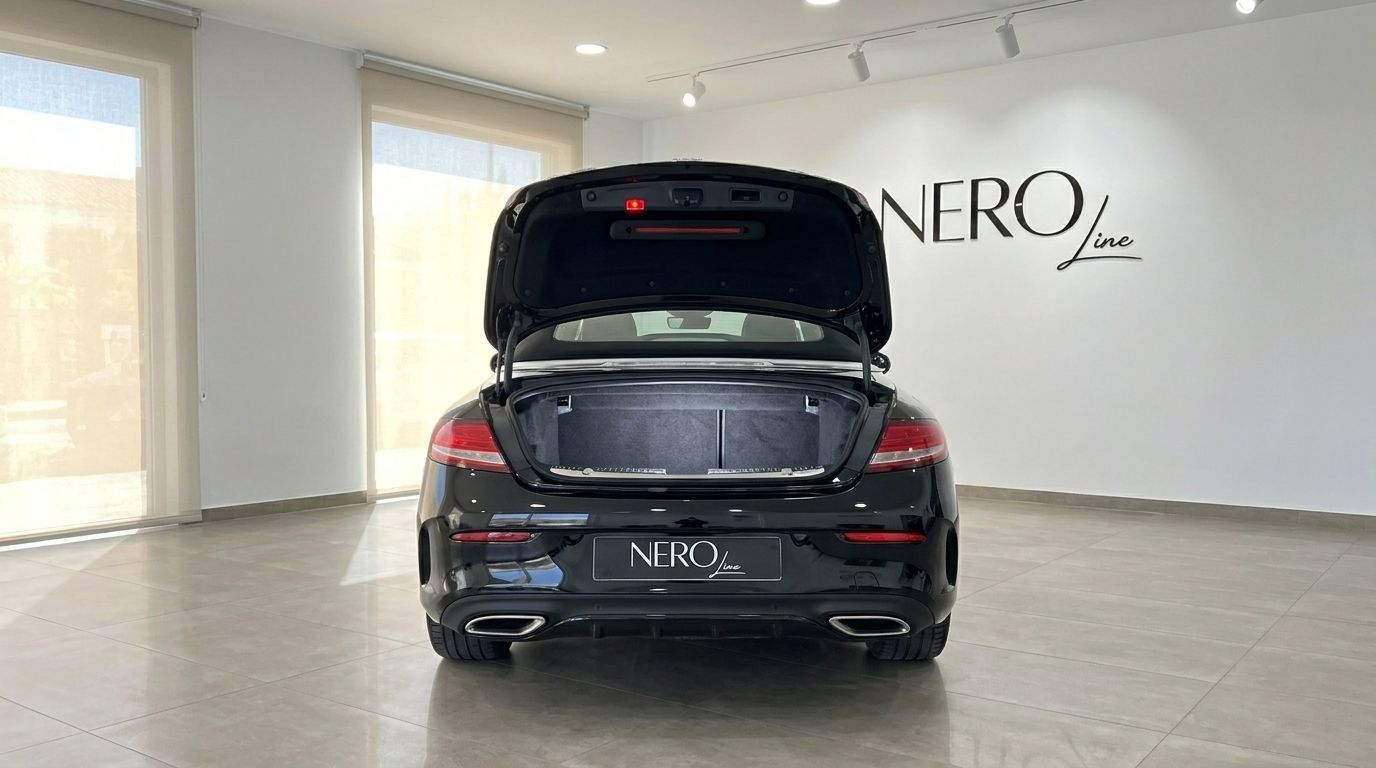 The black Mercedes-Benz C-Class Cabriolet 2020 is shown from the rear with its trunk open in Alicante.