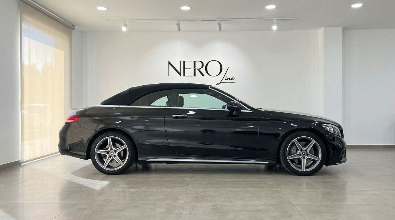 The black 2020 Mercedes-Benz C-Class Cabriolet is shown in a side profile view with its soft top up, parked in a showroom in Alicante.