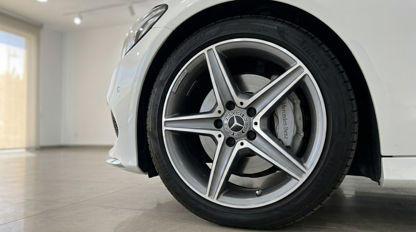 A close-up view of the front wheel and part of the white Mercedes-Benz C 200 Cabriolet's bumper in Alicante.