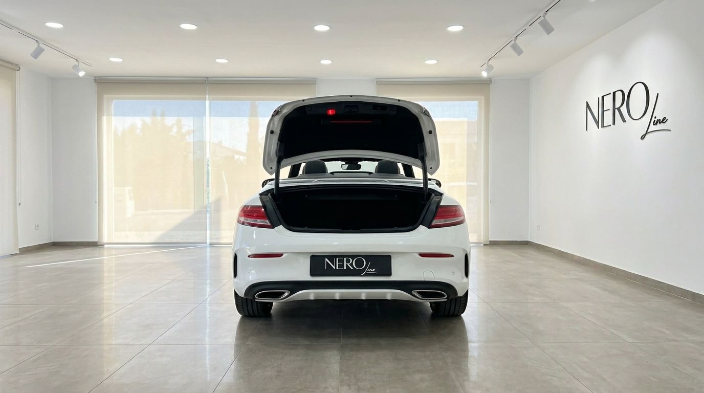 The white Mercedes-Benz C 200 Cabriolet is shown from the rear with its trunk open inside a bright showroom in Alicante.