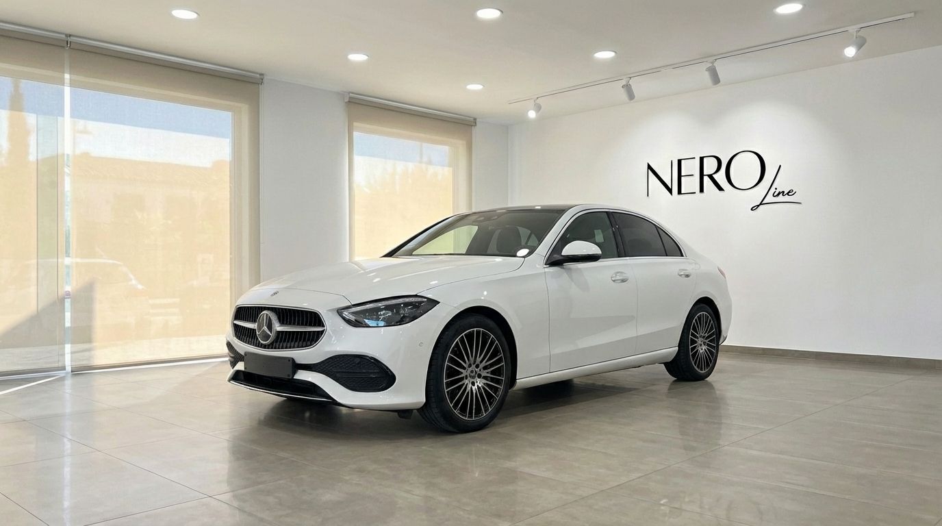 White Mercedes-Benz C220d luxury sedan displayed at a front three-quarter angle in a showroom in Alicante.