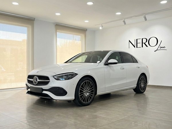 Mercedes-Benz C220d — Luxury sedan in Alicante White Mercedes-Benz C220d luxury sedan displayed at a front three-quarter angle in a showroom in Alicante.