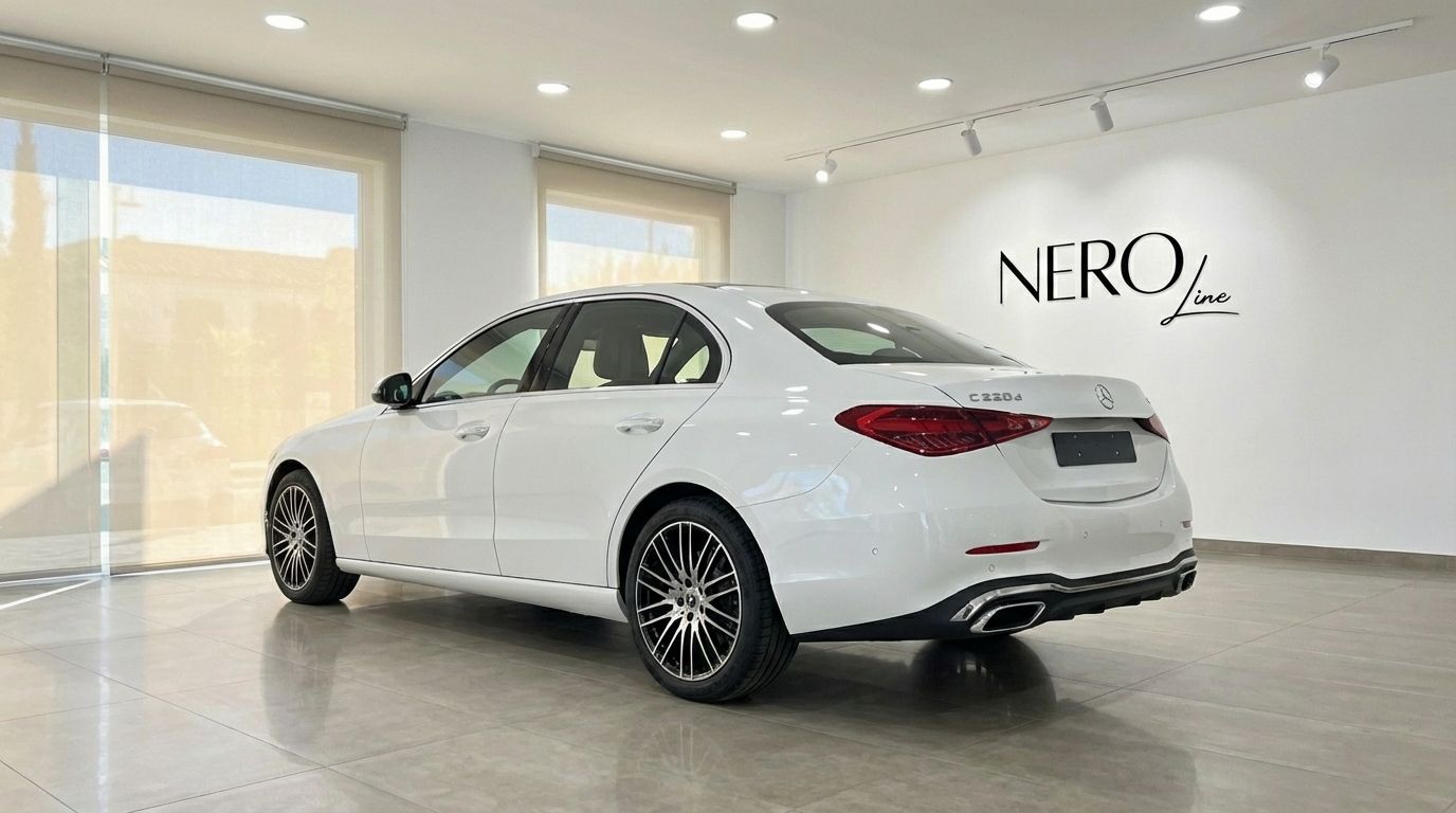 A white 2024 Mercedes-Benz C220d luxury sedan is parked indoors, shown from a rear three-quarter view in Alicante.