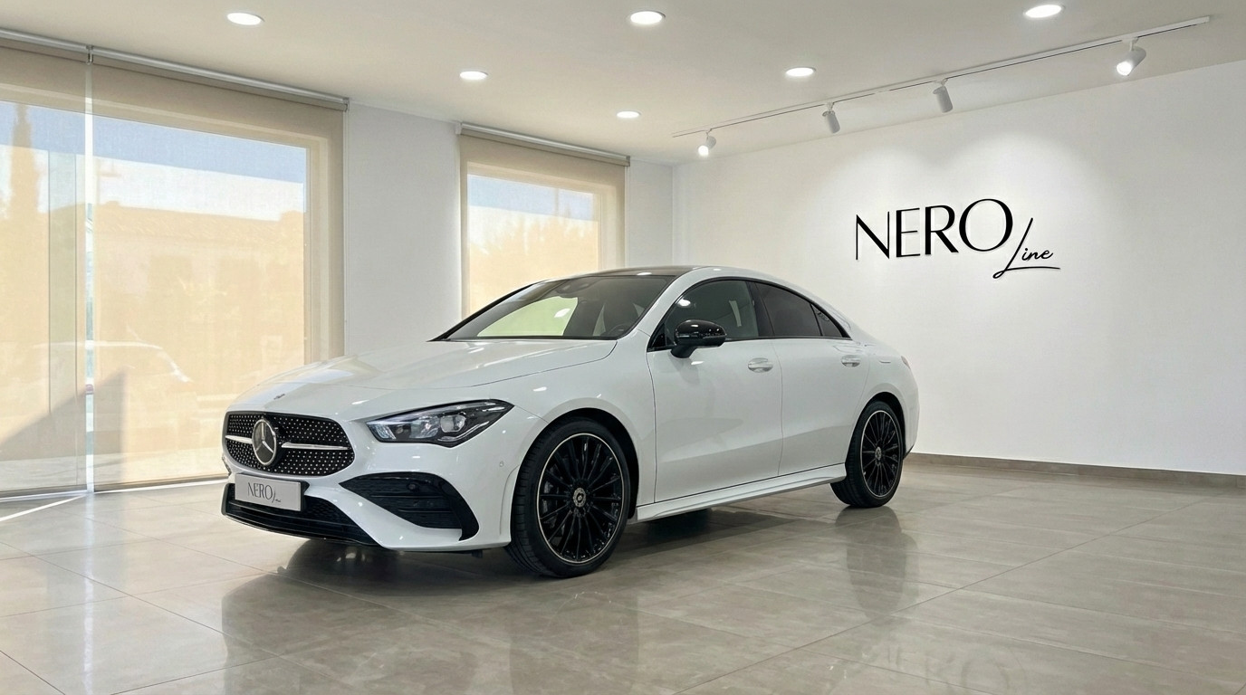 Mercedes-Benz CLA 200 — Front three-quarter view A white Mercedes-Benz CLA 200 is parked indoors, showcasing its sleek front three-quarter view in Alicante.