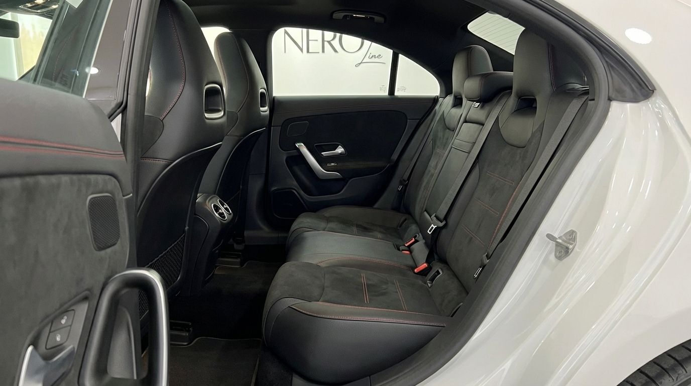 Luxurious rear interior of the Mercedes-Benz CLA 200 in Alicante, showcasing black leather and Alcantara seats with red stitching.