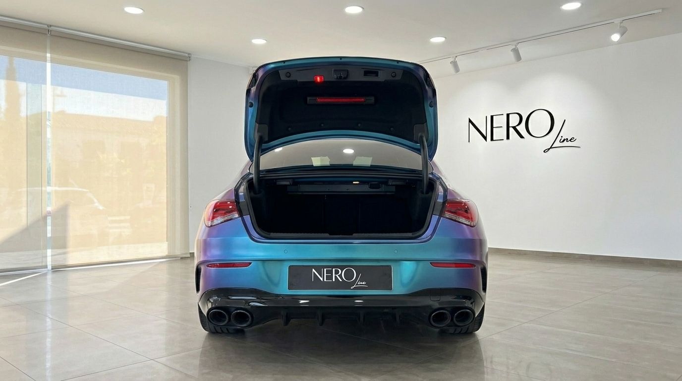 The rear view of the Mercedes-Benz CLA 45 AMG in Alicante, showcasing its open trunk and iridescent paint finish.