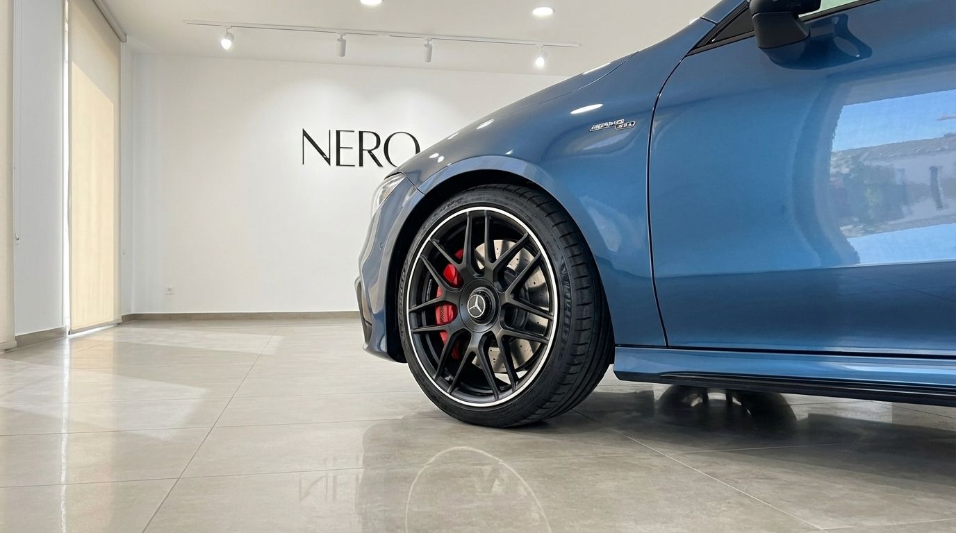 The matte blue Mercedes-Benz CLA 45s AMG, highlighting its sporty front wheel with red calipers, parked in Alicante.