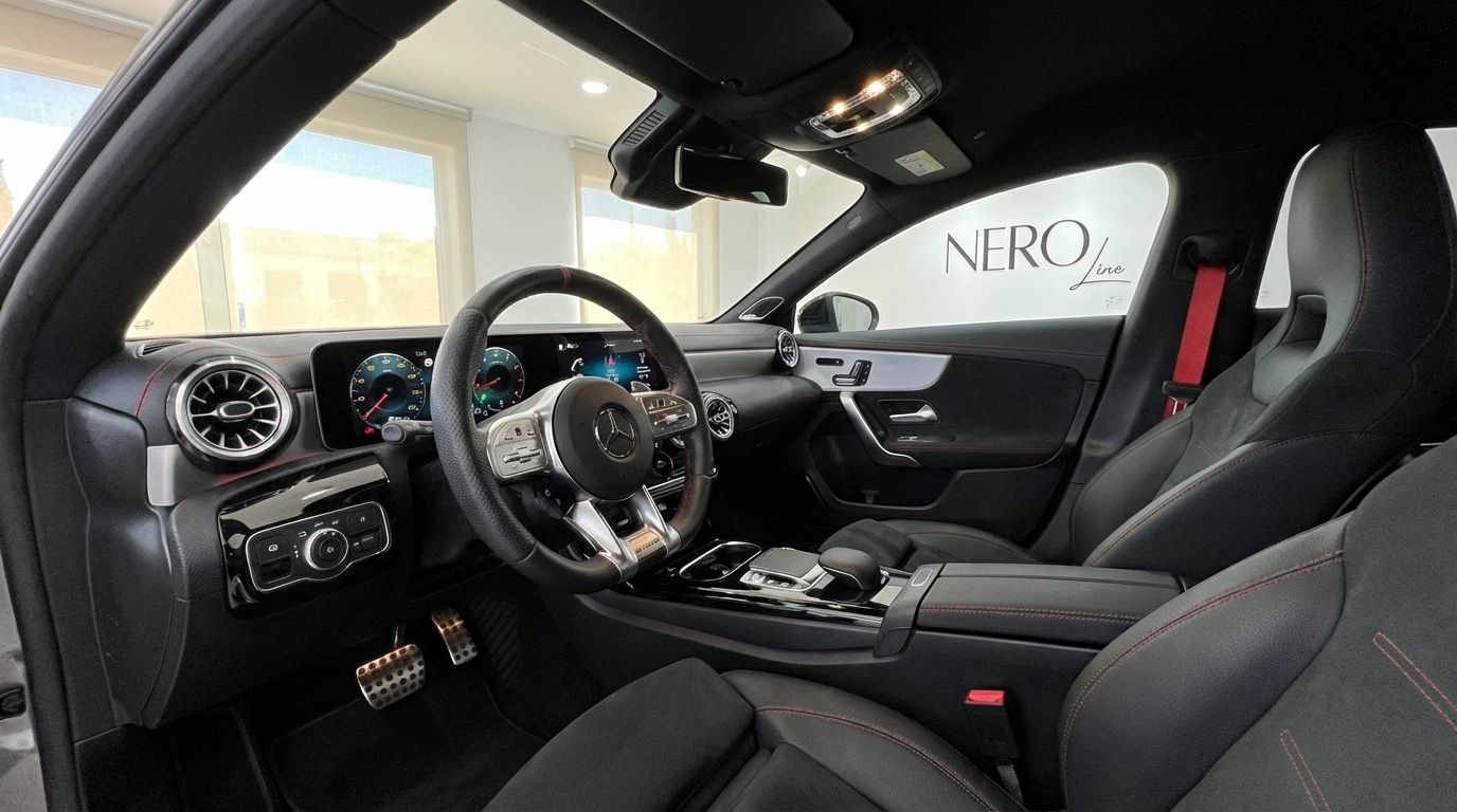 The luxurious interior of the Mercedes-Benz CLA 45s AMG in Alicante, showcasing the driver's cockpit, dashboard, and sport seats with red stitching.