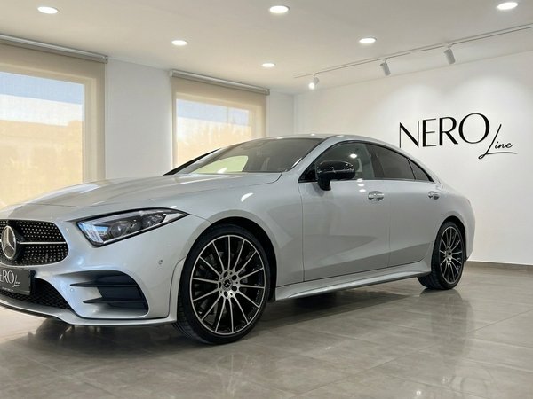 Mercedes-Benz CLS 450 4MATIC — Front view Alicante The elegant silver Mercedes-Benz CLS 450 4MATIC is showcased from a front three-quarter angle in a modern showroom in Alicante.