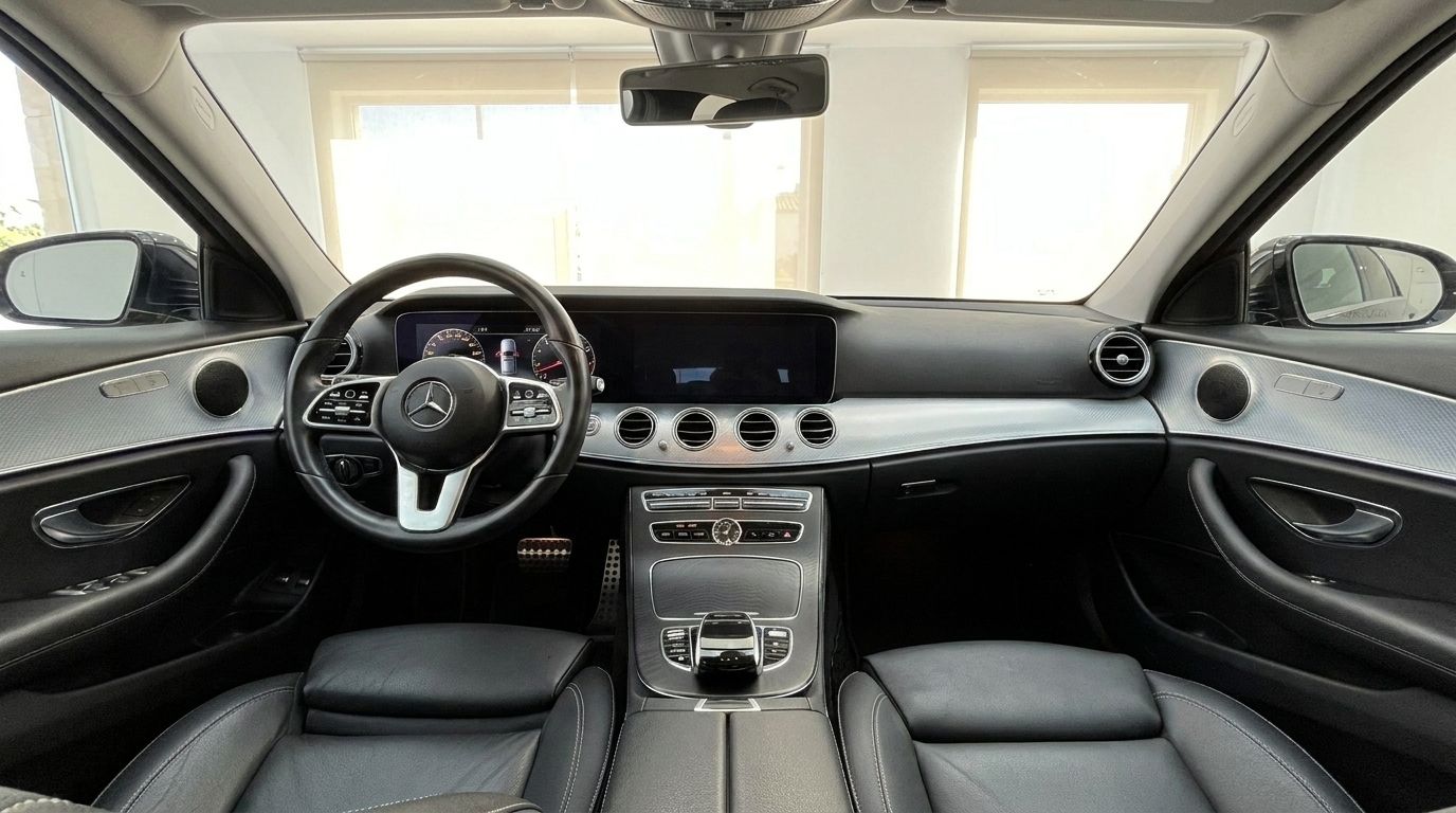 The luxurious interior of the Mercedes-Benz E 300de EQ Power, showcasing the dashboard, steering wheel, and black leather seats in Alicante.