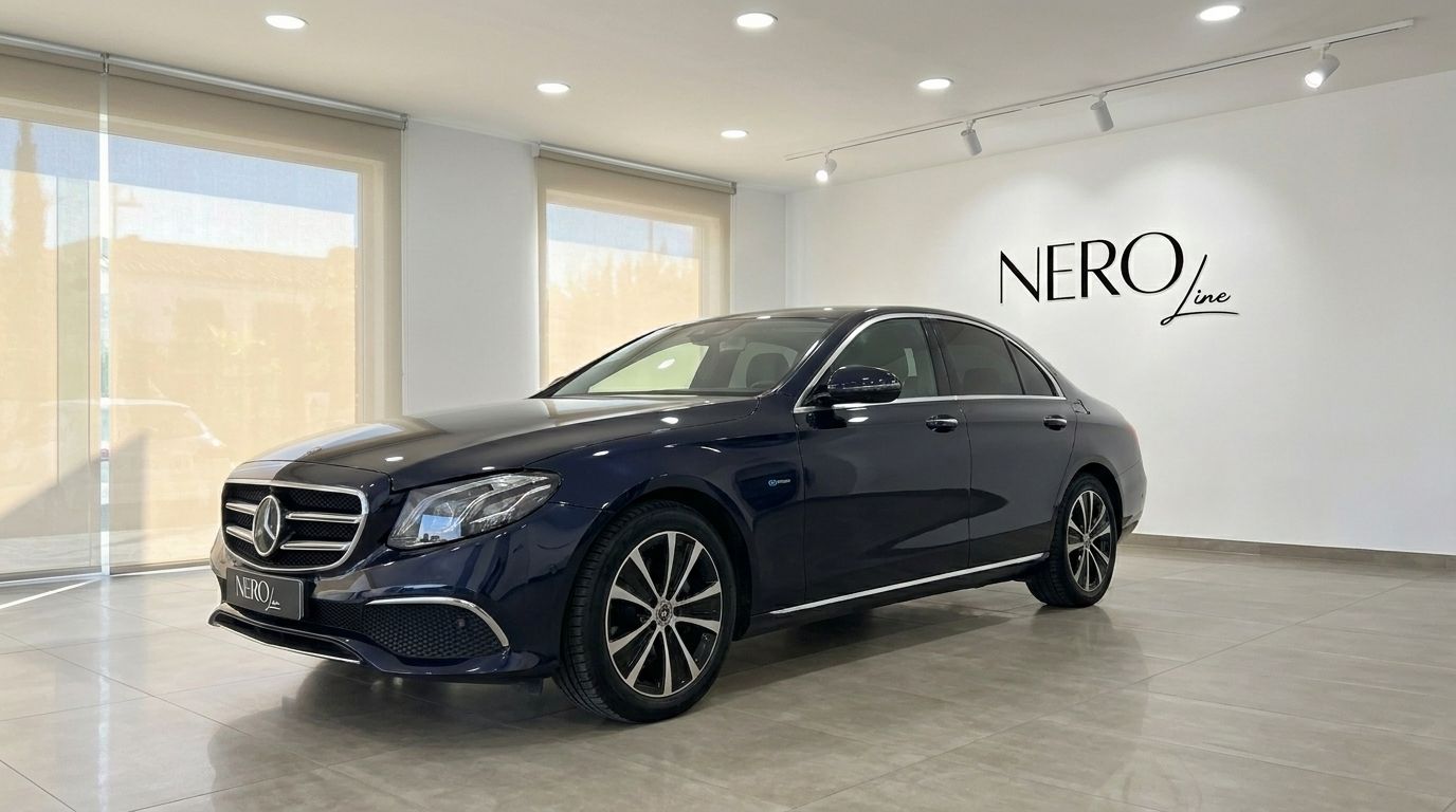 The dark blue Mercedes-Benz E 300de EQ Power is parked at a slight angle in a showroom in Alicante, showing its front and side.