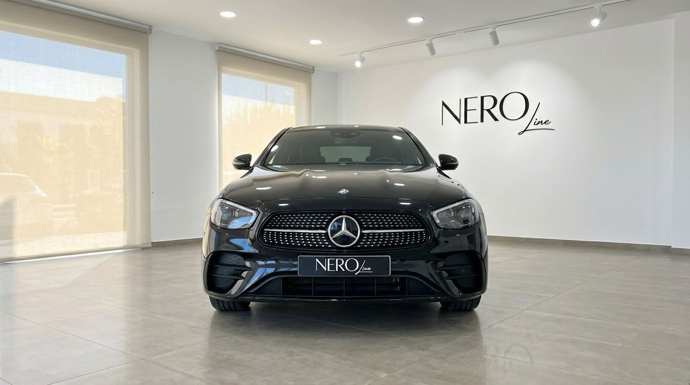 The black 2024 Mercedes-Benz E 300de luxury sedan is prominently displayed from the front in a showroom in Barcelona.