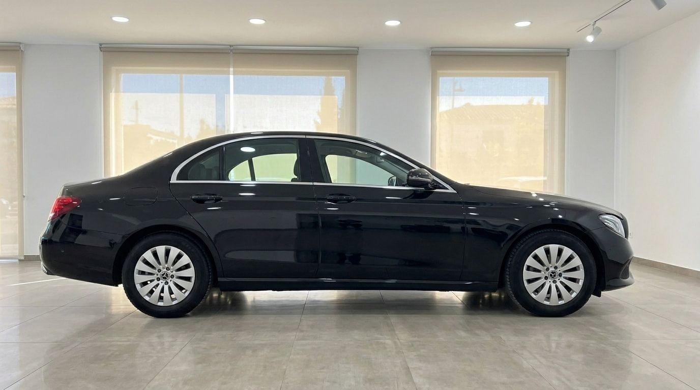 The black Mercedes-Benz E-Class sedan is shown in a full side profile view, parked indoors in Alicante.