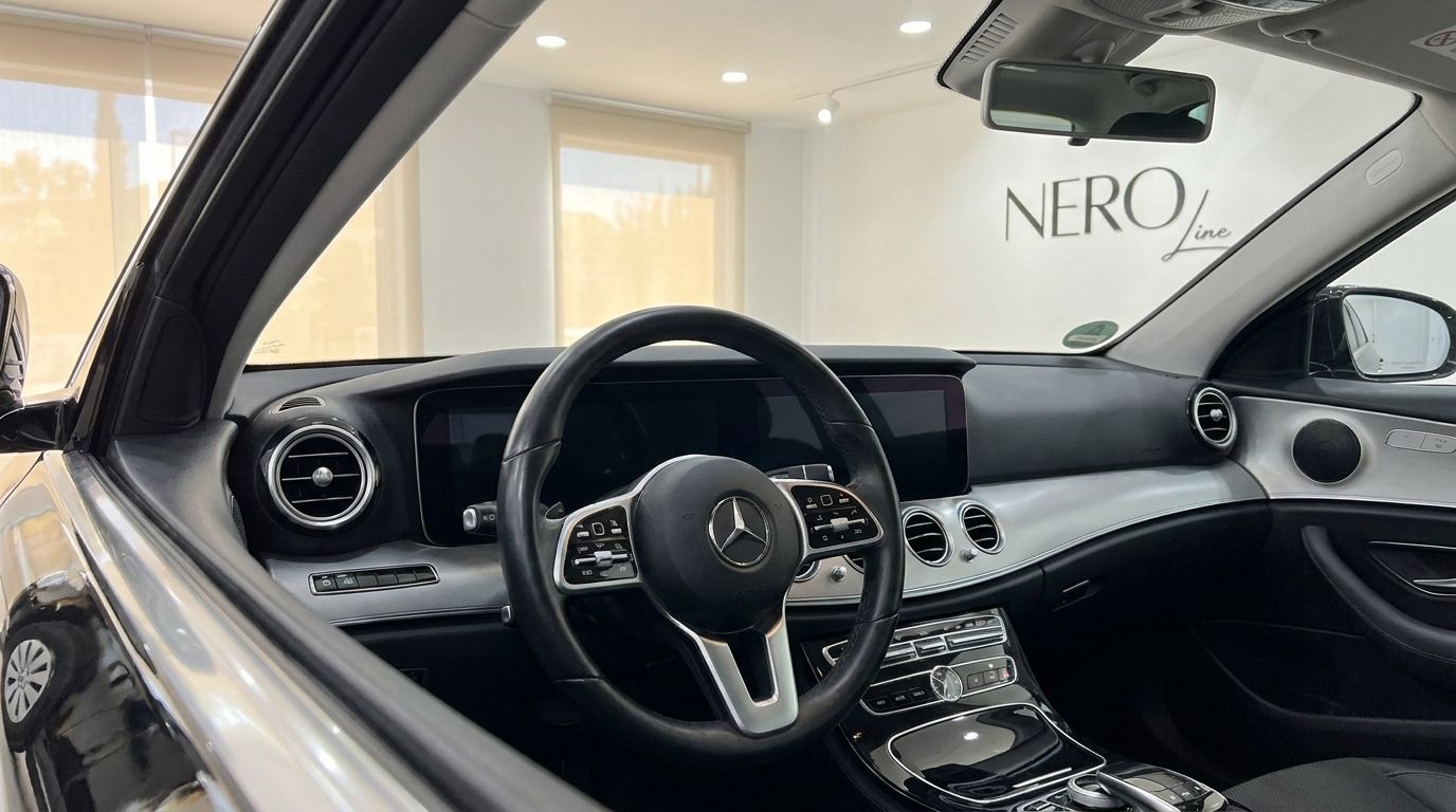 The interior of the Mercedes-Benz E-Class in Alicante, showing the steering wheel, dashboard, and infotainment screen.