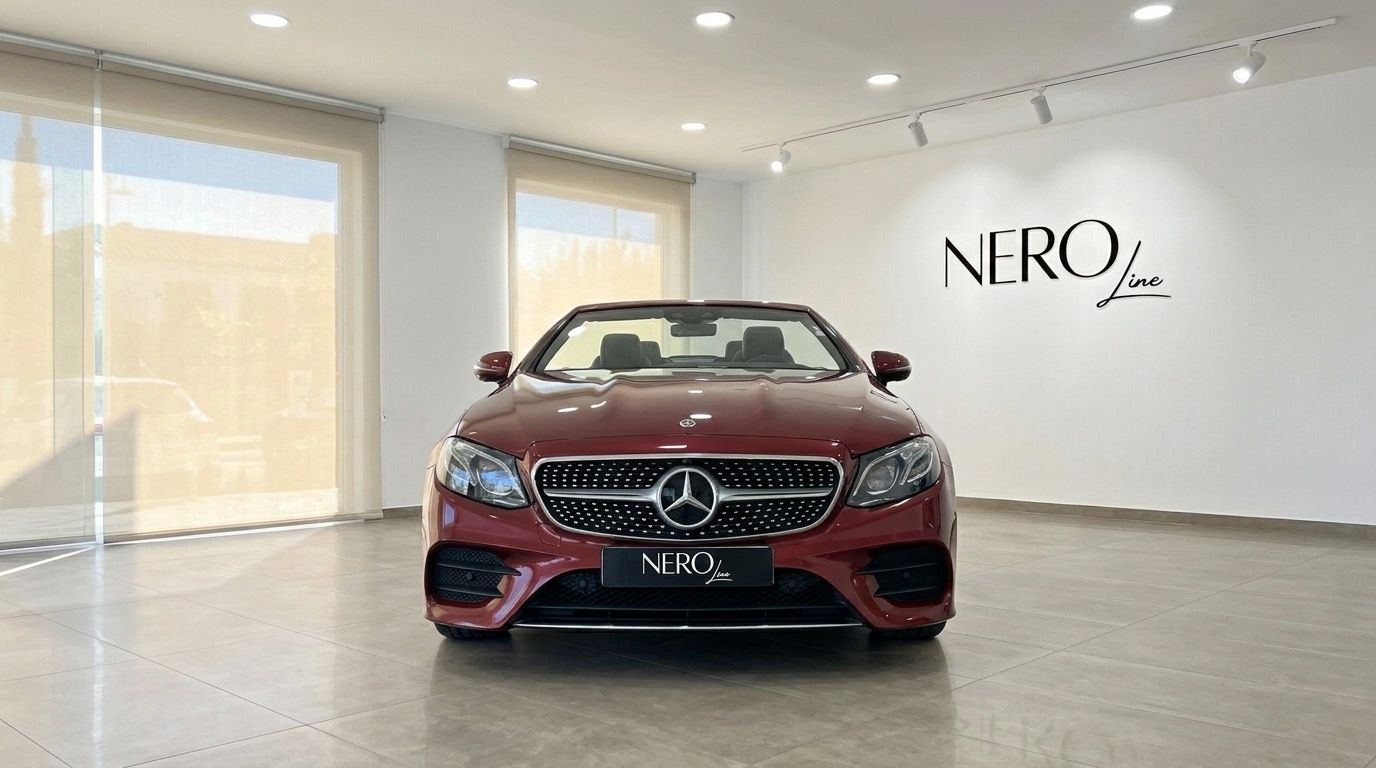 The burgundy red Mercedes-Benz E-Class Cabrio AMG Line is prominently displayed from the front in a bright showroom.