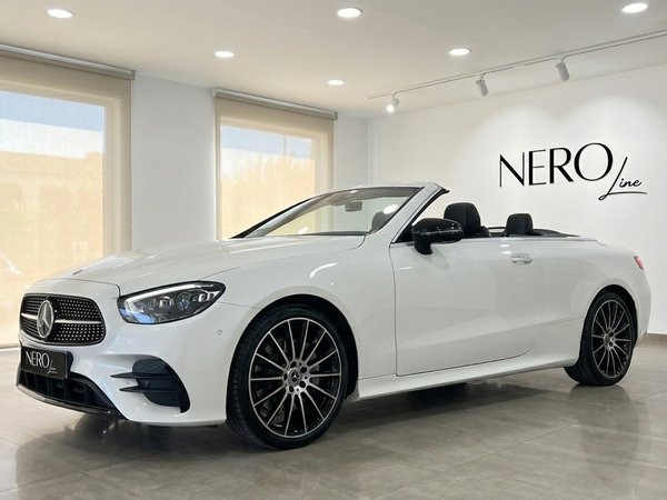 Mercedes-Benz E200 Cabrio — Cabriolet de luxe à Marbella La Mercedes-Benz E200 Cabrio blanche, un cabriolet de luxe, est présentée de trois quarts avant dans un showroom à Marbella.