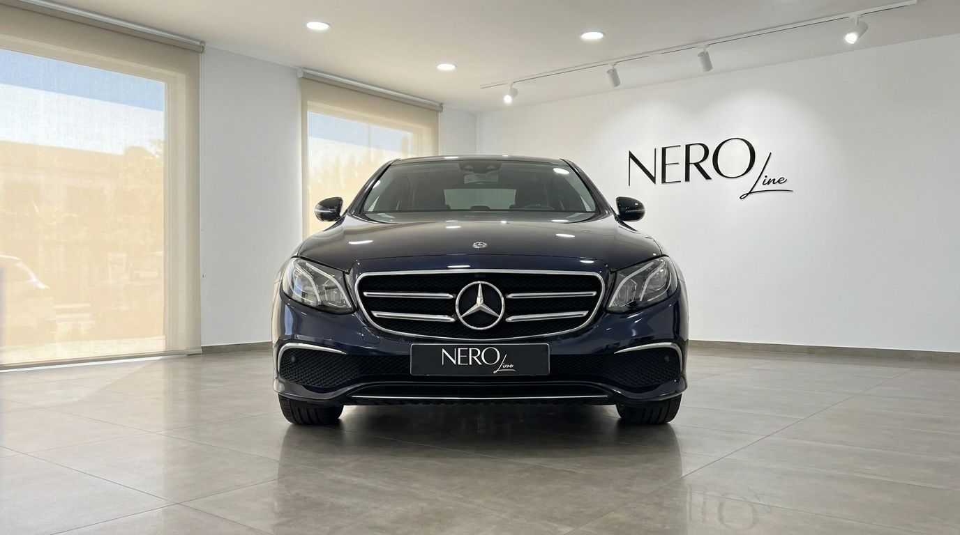 The front view of a dark blue Mercedes-Benz E 300de EQ Power luxury car parked in a showroom in Alicante.