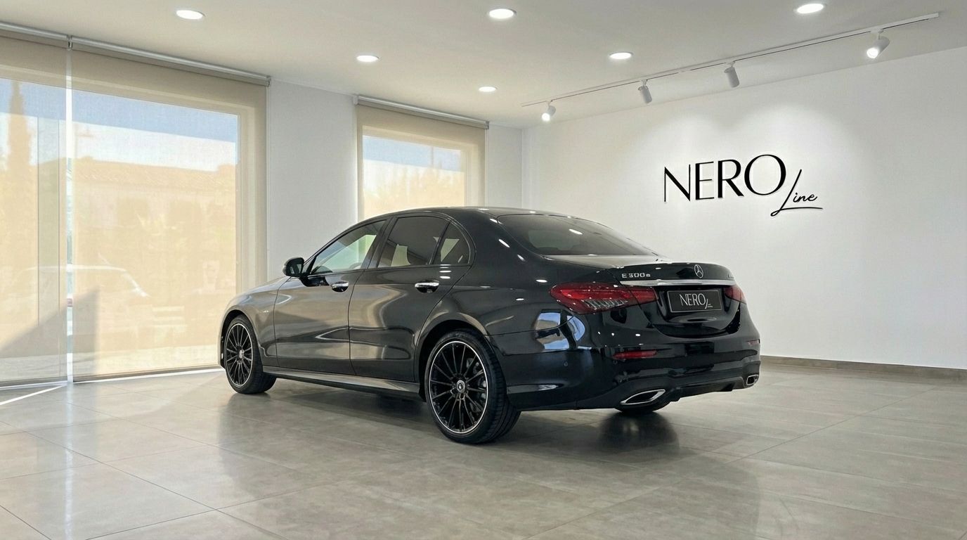 The sleek black Mercedes-Benz E300e AMG line is showcased from a rear three-quarter view inside a modern showroom in Alicante.