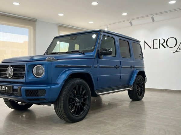 Mercedes-Benz G 580 EQ — Matte Dark Blue SUV The matte dark blue Mercedes-Benz G 580 EQ is showcased in a front three-quarter view inside a showroom in Mallorca.