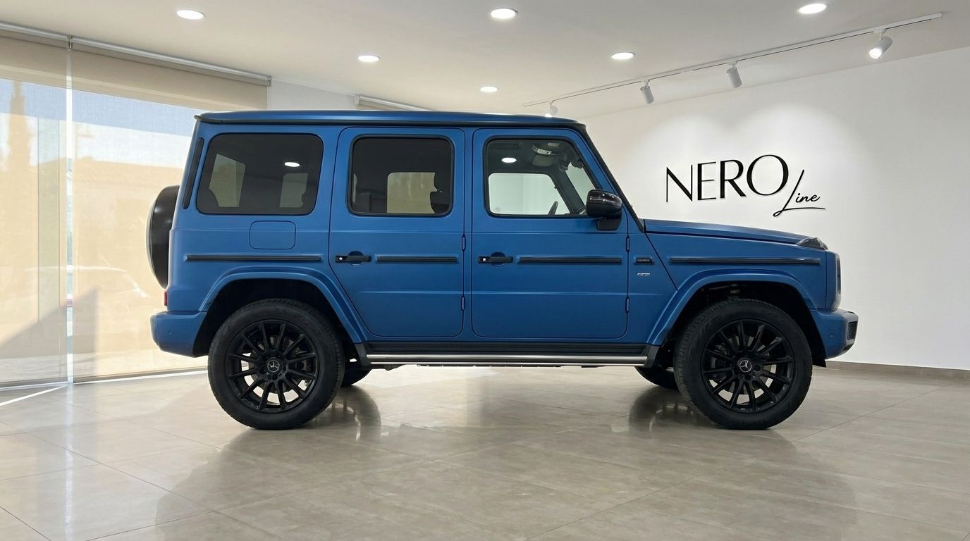Matte dark blue Mercedes-Benz G 580 EQ electric SUV, captured in a side profile view inside a showroom in Mallorca.