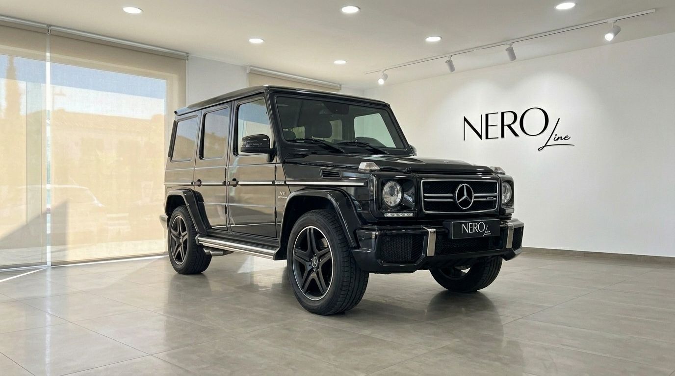 A sleek black Mercedes-Benz G 500 (AMG Styling) is showcased in a modern showroom in Alicante, presented from a front three-quarter angle.