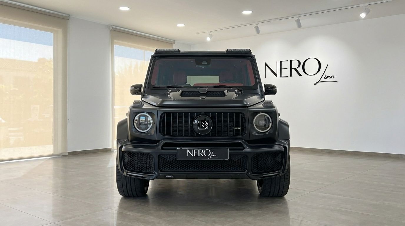 The matte black Mercedes-Benz G63 800 BRABUS is showcased from the front view in a bright showroom in Ibiza.