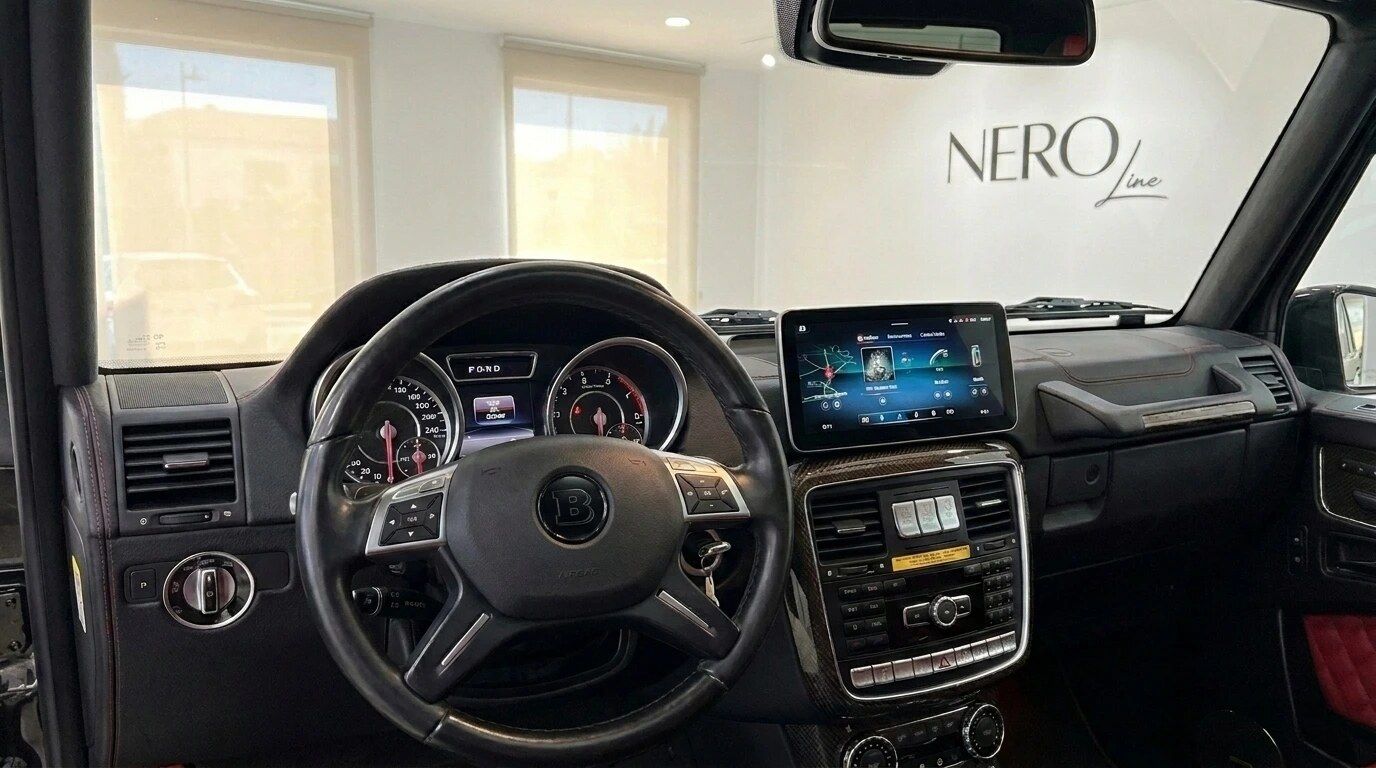 Das Bild zeigt das luxuriöse schwarze Interieur-Cockpit des Brabus G800 Rocket in Alicante, mit Lenkrad, Armaturenbrett und Infotainment-Bildschirm.