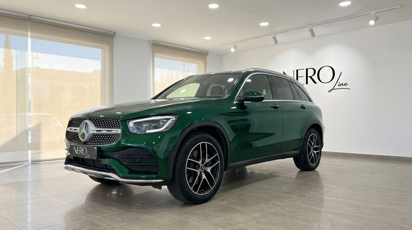 A gloss emerald green 2021 Mercedes-Benz GLC SUV, shown from the front three-quarter angle, parked in a showroom in Mallorca.