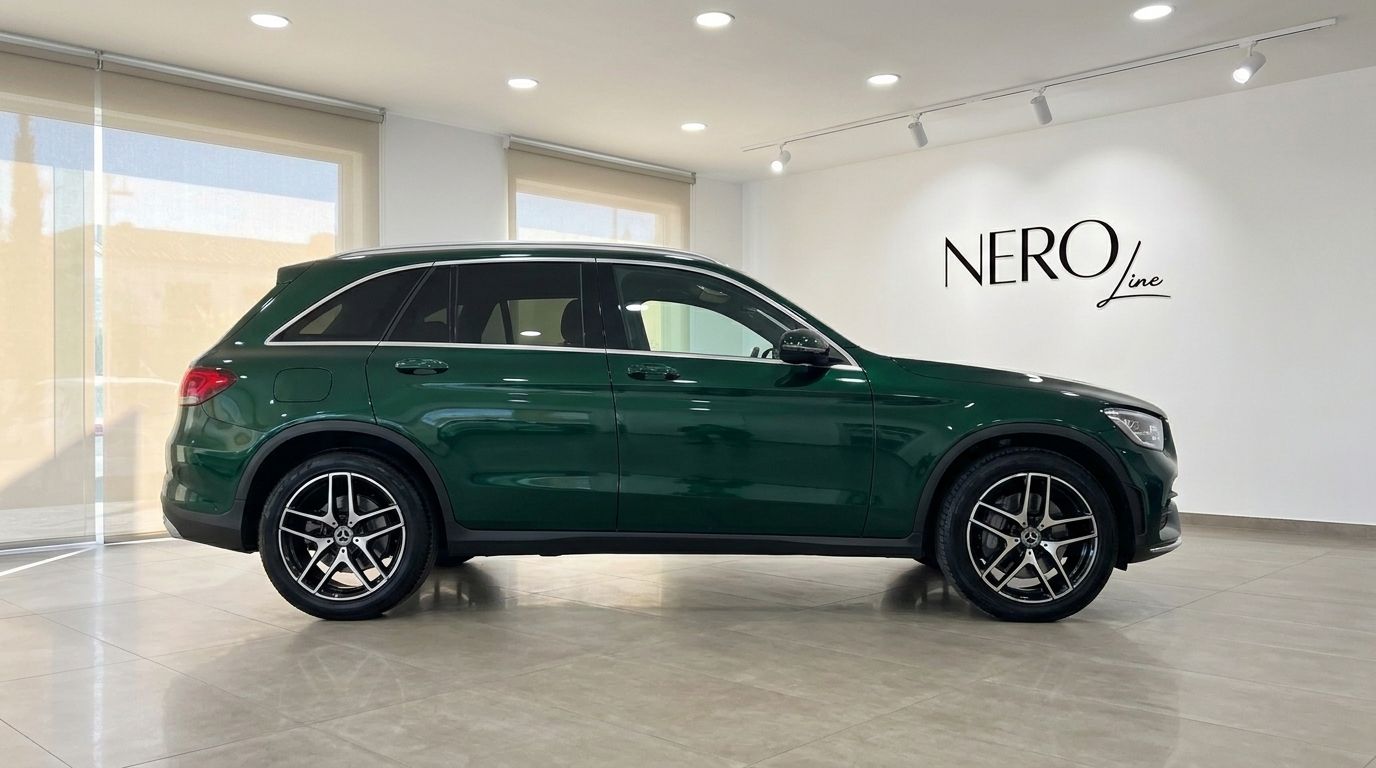 The dark green Mercedes-Benz GLC SUV is showcased in a showroom, viewed from its elegant side profile in Mallorca.