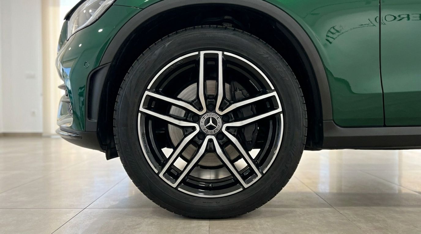 Close-up of the Gloss Emerald Green Mercedes-Benz GLC's front wheel and fender, showcasing its elegant design in Mallorca.