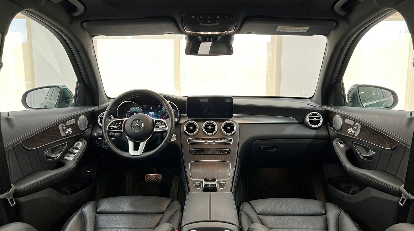 The luxurious interior of the Mercedes-Benz GLC features a detailed dashboard, steering wheel, infotainment screen, and black leather seats.