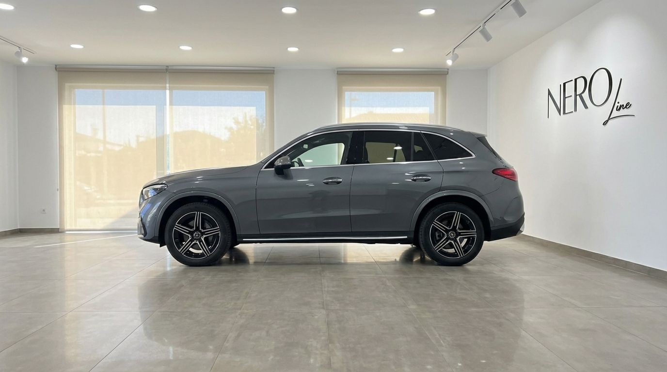 The metallic grey 2025 Mercedes-Benz GLC 200 SUV is showcased in a showroom, viewed from its side profile in Alicante.