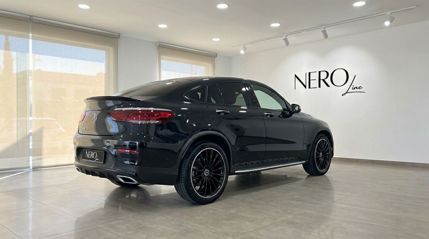 El elegante SUV coupé Mercedes-Benz GLC 300 AMG Line negro está aparcado en un moderno concesionario en Ibiza, mostrando su perfil trasero tres cuartos.