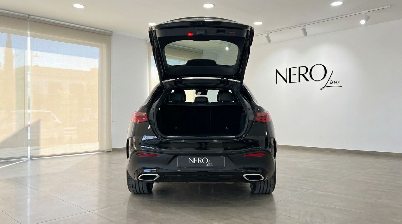 El Mercedes-Benz GLC 300 AMG Line negro desde la parte trasera con el maletero abierto, mostrando el espacio de carga en un showroom de Ibiza.