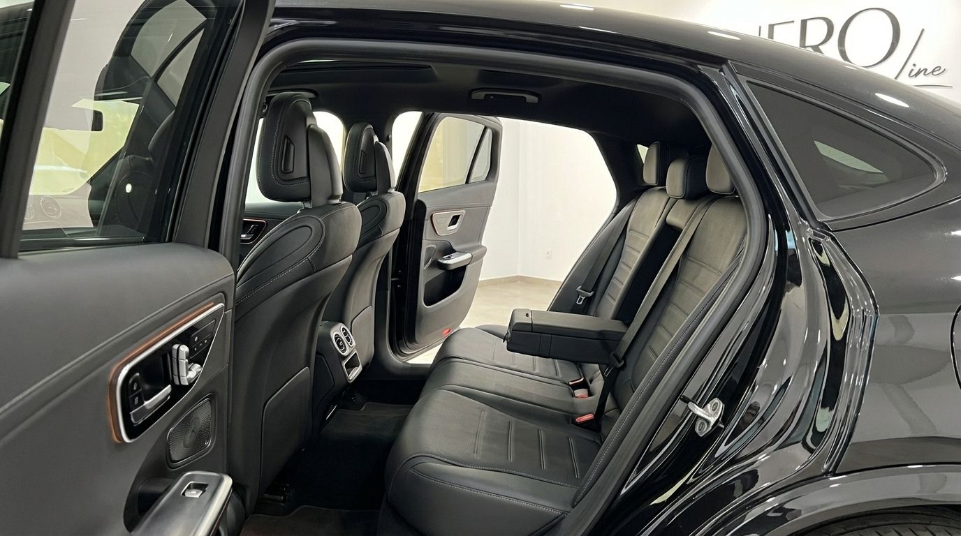 The luxurious rear interior of the Mercedes-Benz GLC 300d Coupe in Alicante, featuring elegant black leather seats and an open door.