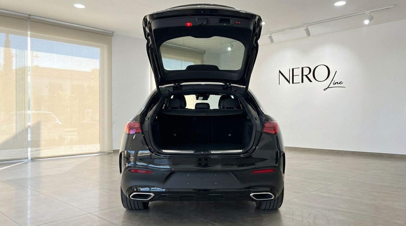 Rear view of the metallic black 2025 Mercedes-Benz GLC 300d Coupe with its trunk open, showcasing ample cargo space in Alicante.