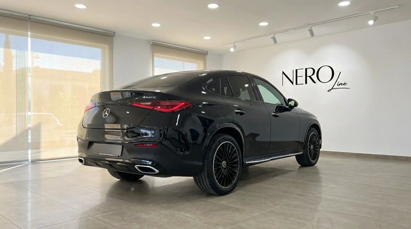 The metallic black 2025 Mercedes-Benz GLC 300d Coupe is shown from a rear three-quarter angle in a showroom in Alicante.