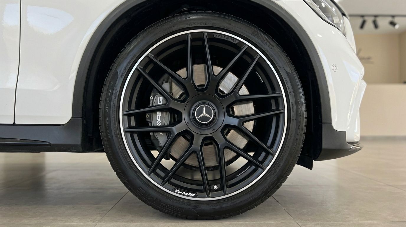 The white Mercedes-Benz GLC 63 S AMG showcases its black multi-spoke front wheel and AMG brake caliper in Marbella.