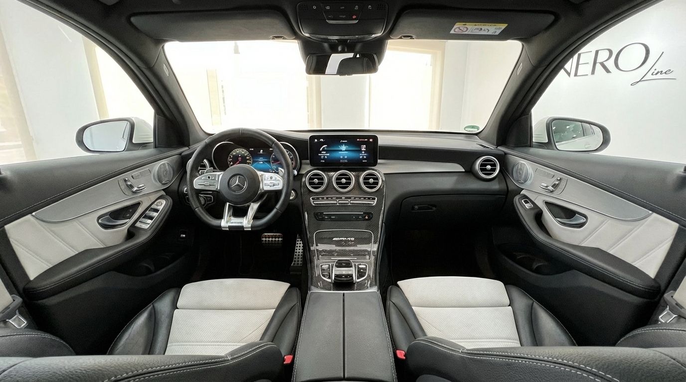 The luxurious interior of the Mercedes-Benz GLC 63 S AMG in Marbella, featuring a detailed view of the dashboard, steering wheel, and black and white seats.