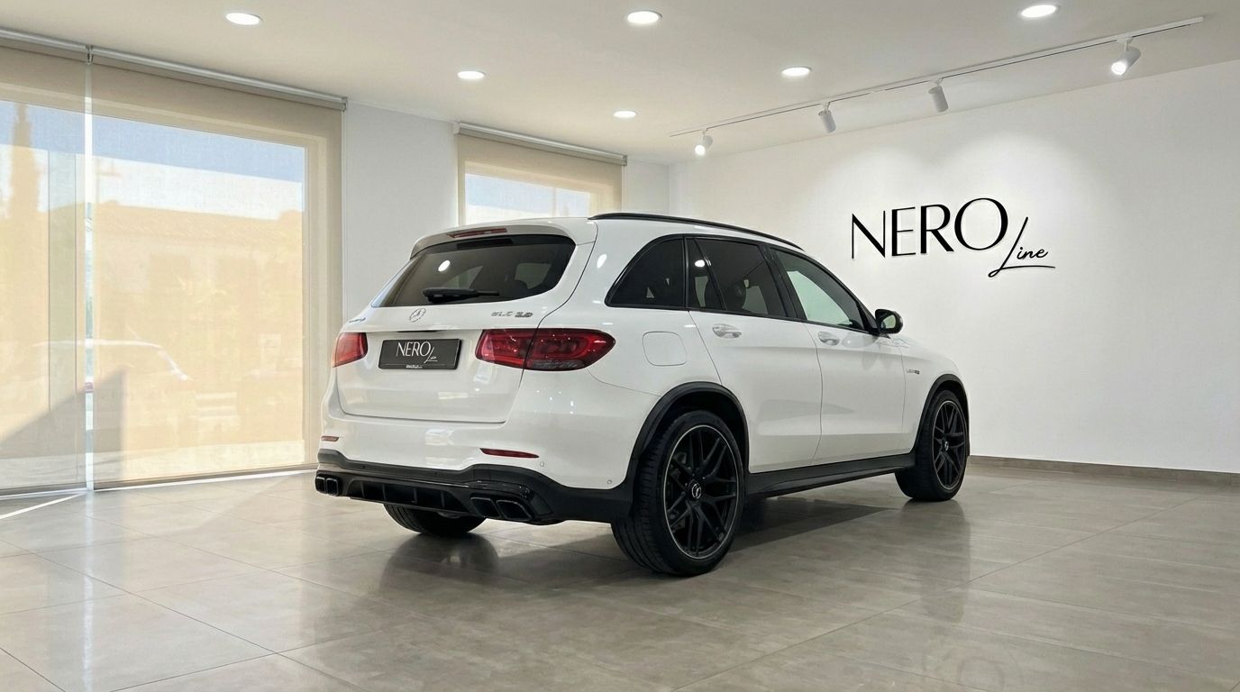 A white Mercedes-Benz GLC 63 S AMG, 2022 model, is parked in a showroom in Marbella, showing its rear three-quarter view.