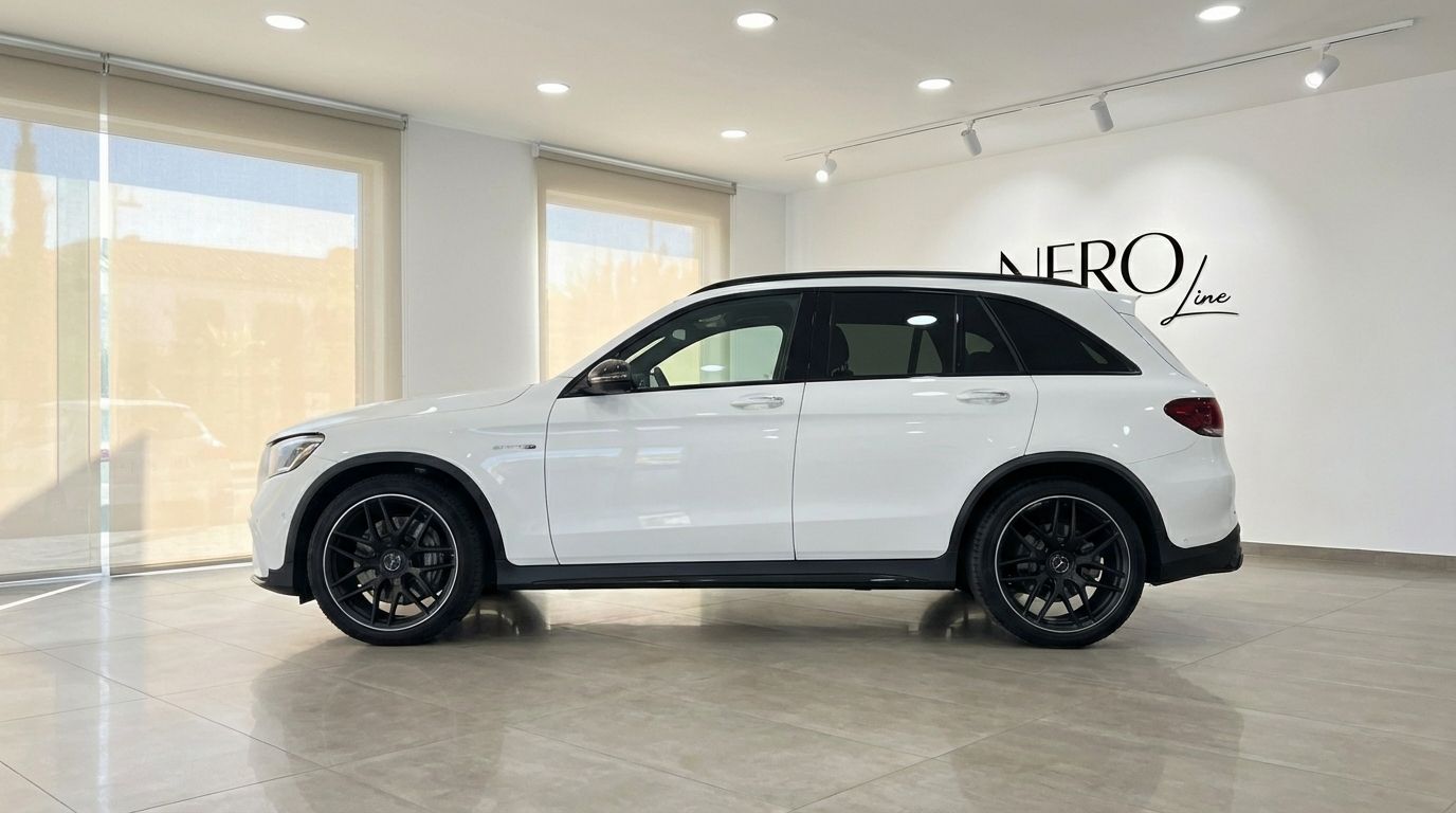 The white 2022 Mercedes-Benz GLC 63 S AMG luxury SUV is shown from its side profile in a showroom in Marbella.