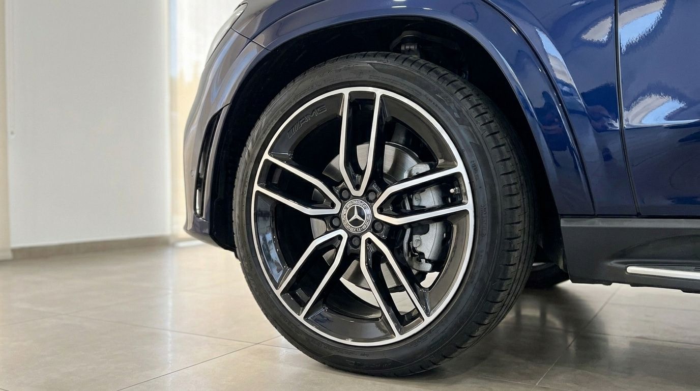 Primer plano del guardabarros delantero azul oscuro metalizado y la llanta AMG multirradio del Mercedes-Benz GLE 350de en Alicante.