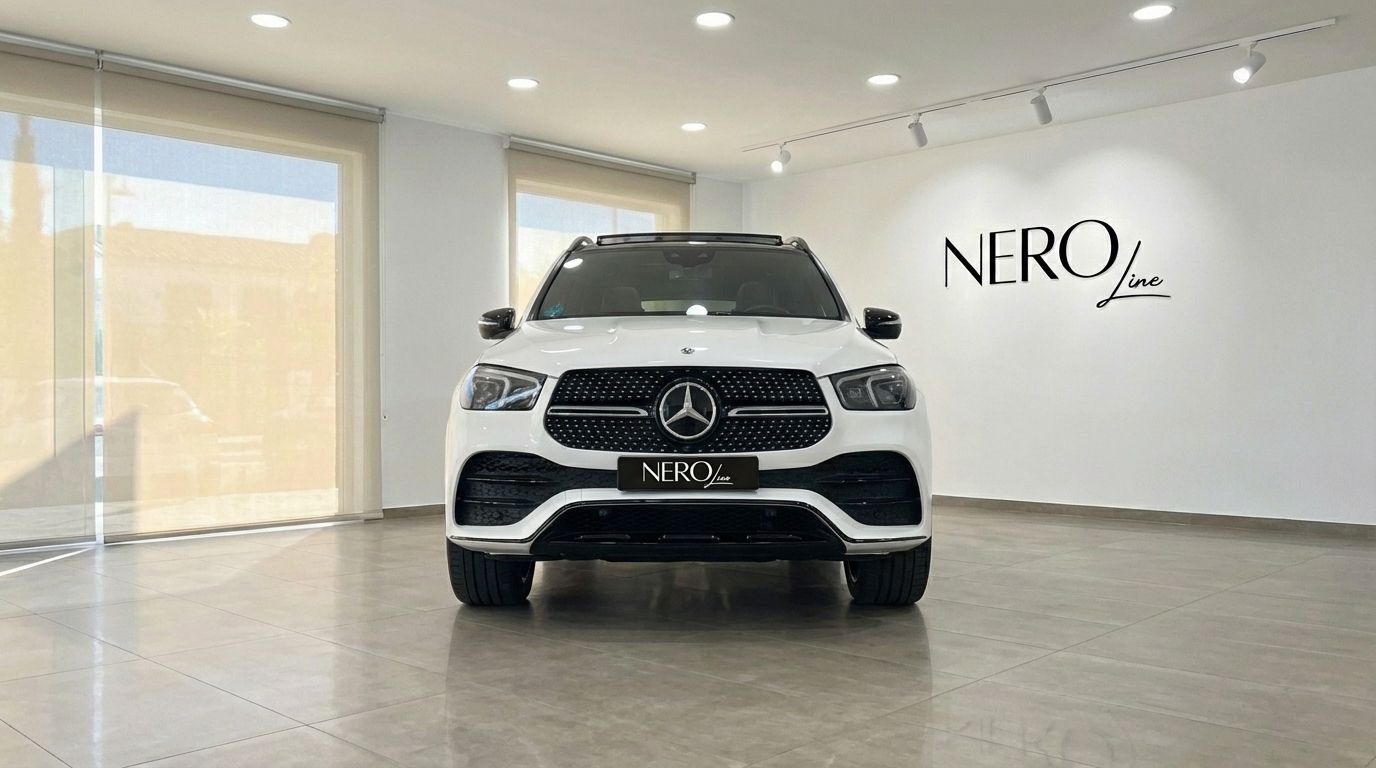 The white Mercedes-Benz GLE 350e AMG is prominently displayed from the front in a showroom in Alicante.