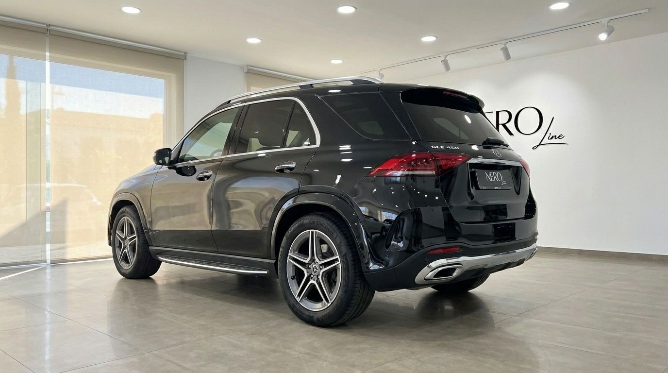 El Mercedes-Benz GLE 450 AMG negro brillante se muestra desde un ángulo trasero de tres cuartos dentro de una moderna sala de exposición en Madrid.