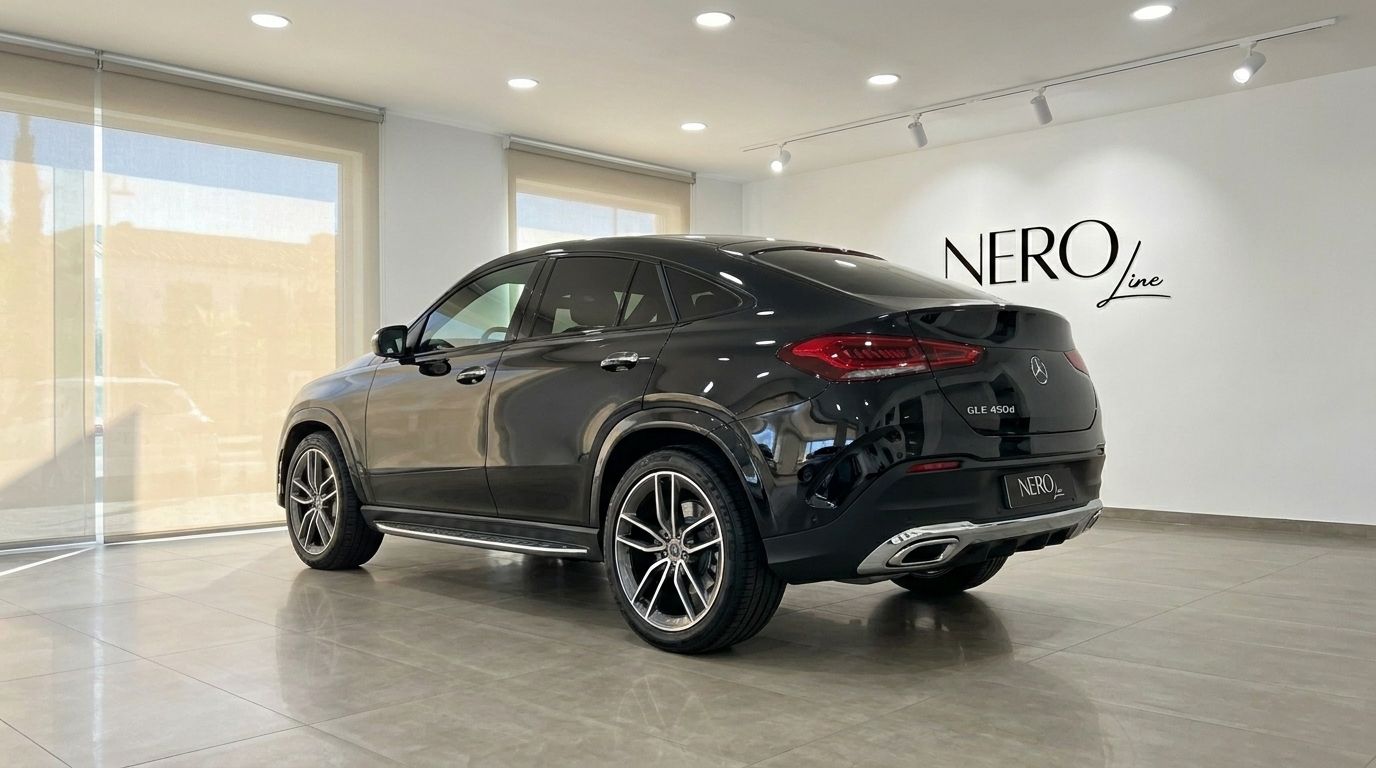 The gloss Obsidian Black Mercedes-Benz GLE 450d is parked in a showroom in Marbella, captured from a rear three-quarter angle.