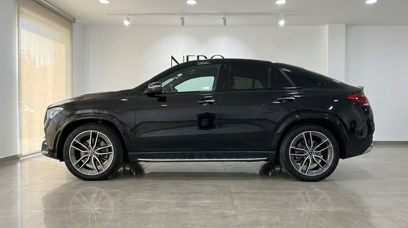 The black 2024 Mercedes-Benz GLE 450d luxury SUV is shown from a side profile in a showroom in Marbella.