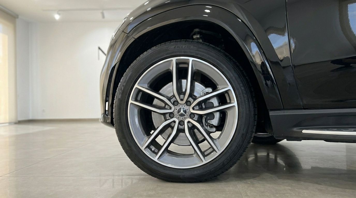 Close-up of the front wheel and side profile of the gloss Obsidian Black 2024 Mercedes-Benz GLE 450d in Marbella.