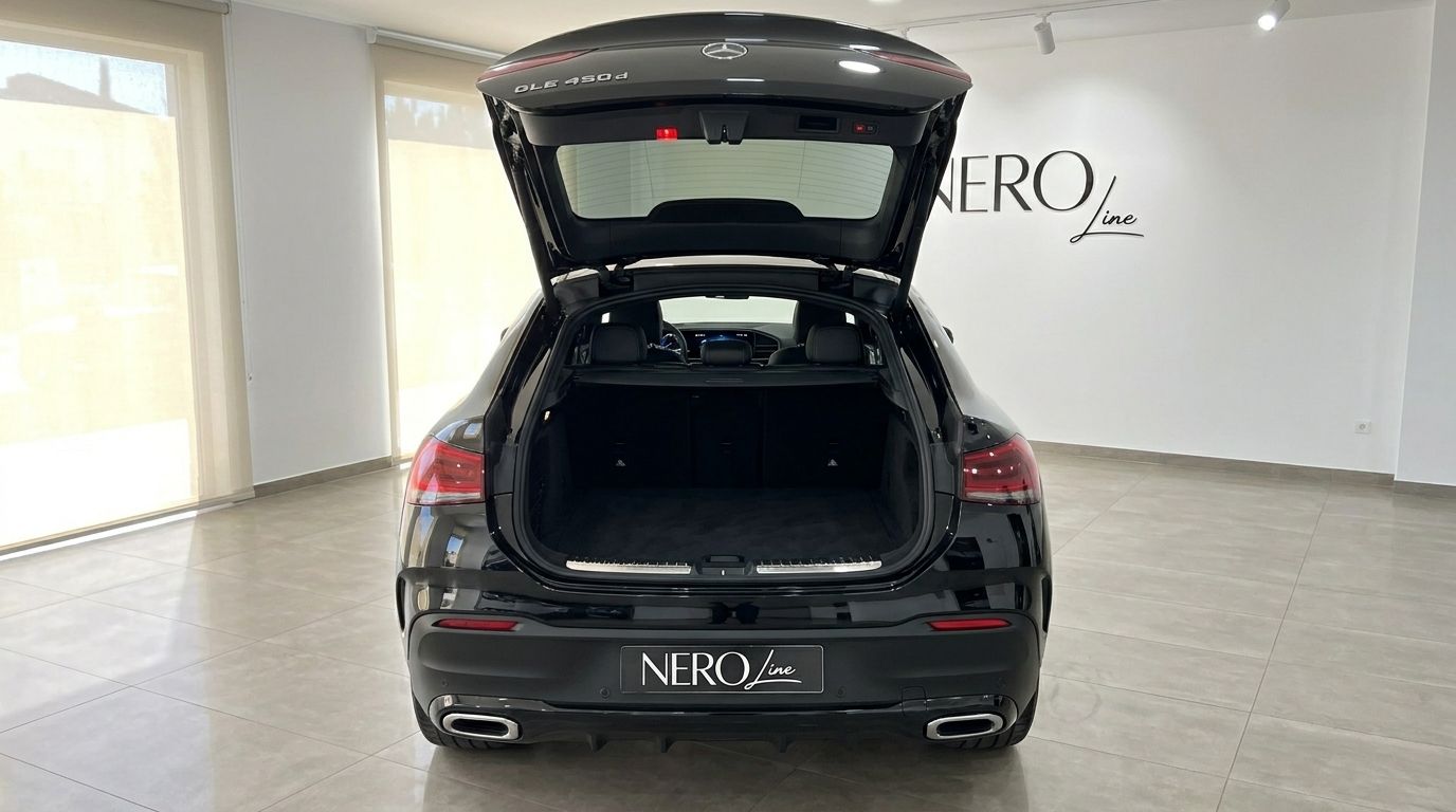 The rear view of the gloss Obsidian Black Mercedes-Benz GLE 450d in Marbella, showcasing its open trunk and spacious cargo area.